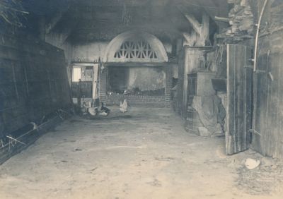 Interior shot of Klauseck, around 1917. The cow and horse barn was located on the left, behind the big wooden flaps. At the end of the hall was a large open fireplace with a crackling log fire.