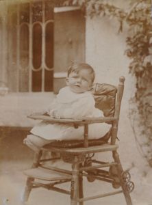 Otto Blum 1912 in dem typischen Kinderhochstuhl der Zeit. In der hölzernen Sitzfläche war ein rundes Loch, unter dem man ein Töpfchen befestigen konnte. Der Stuhl ließ sich umklappen, dann entstand ein niedriges Stühlchen mit einem kleinen Tisch davor.